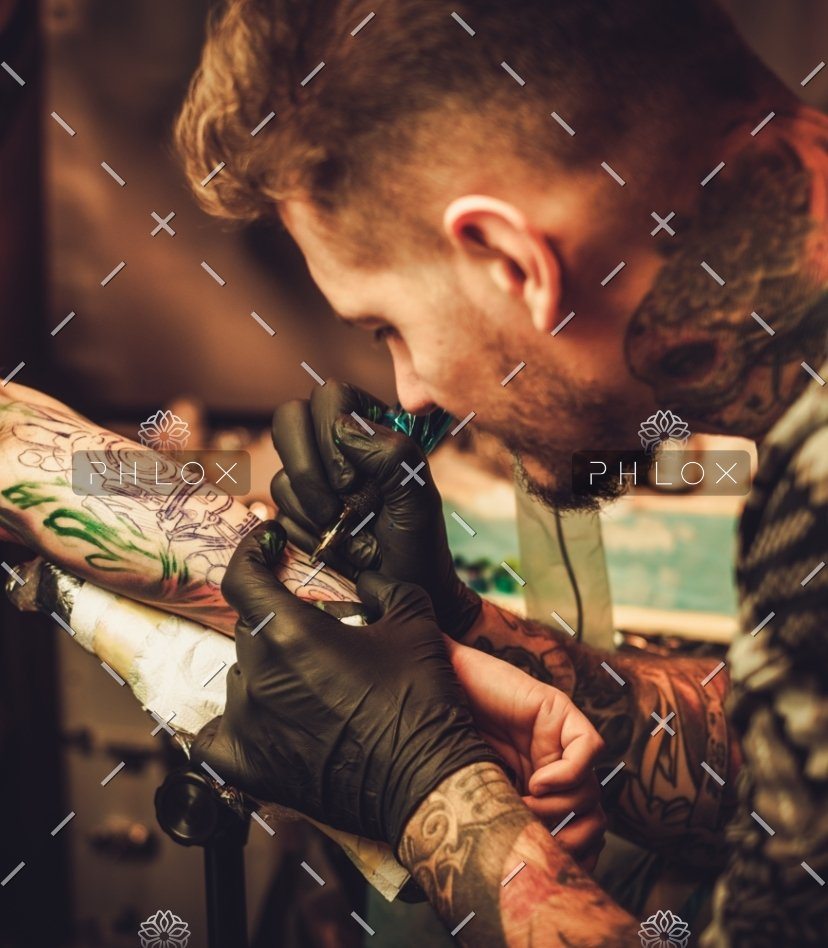 demo-attachment-125-tattoo-artist-makes-a-tattoo-on-a-mans-hand-PECZRE2